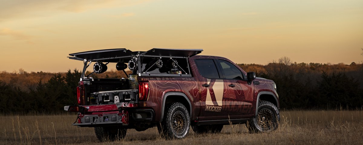 GMC Sierra rear-side view at sunset