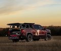 GMC Sierra rear-side view at sunset