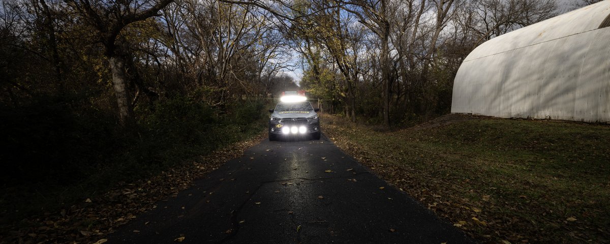 Subaru CrossTrek headlights visible on a dark wooded road
