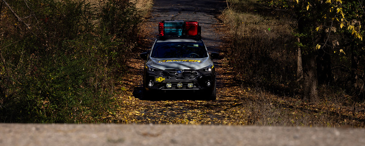 Subaru CrossTrek approaching on a wooded trail