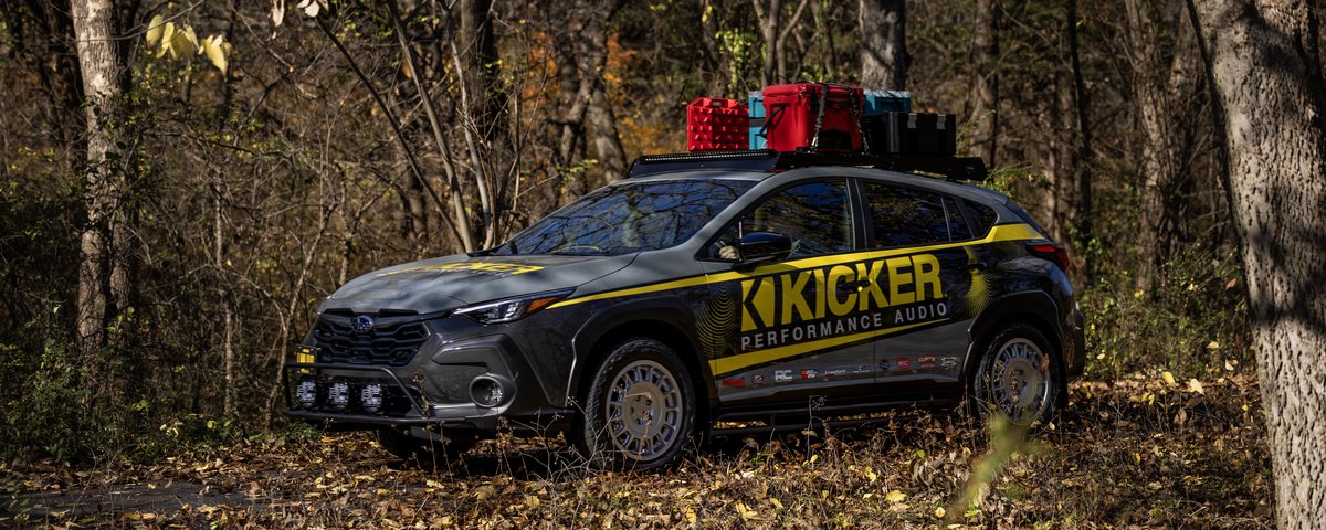 Subaru CrossTrek side view among autumn trees