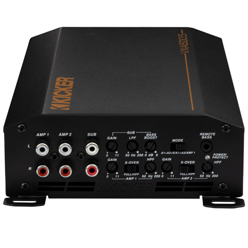 KICKER bass level remote knob in focus with blurred amplifier in background.